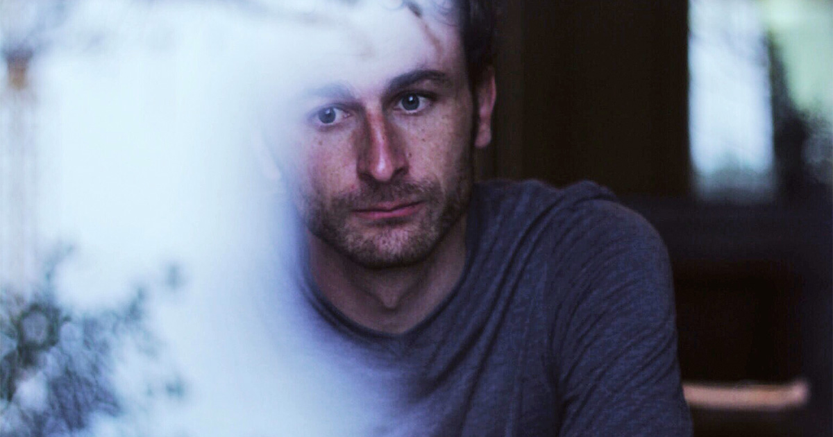 Sad looking man behind a glass reflection