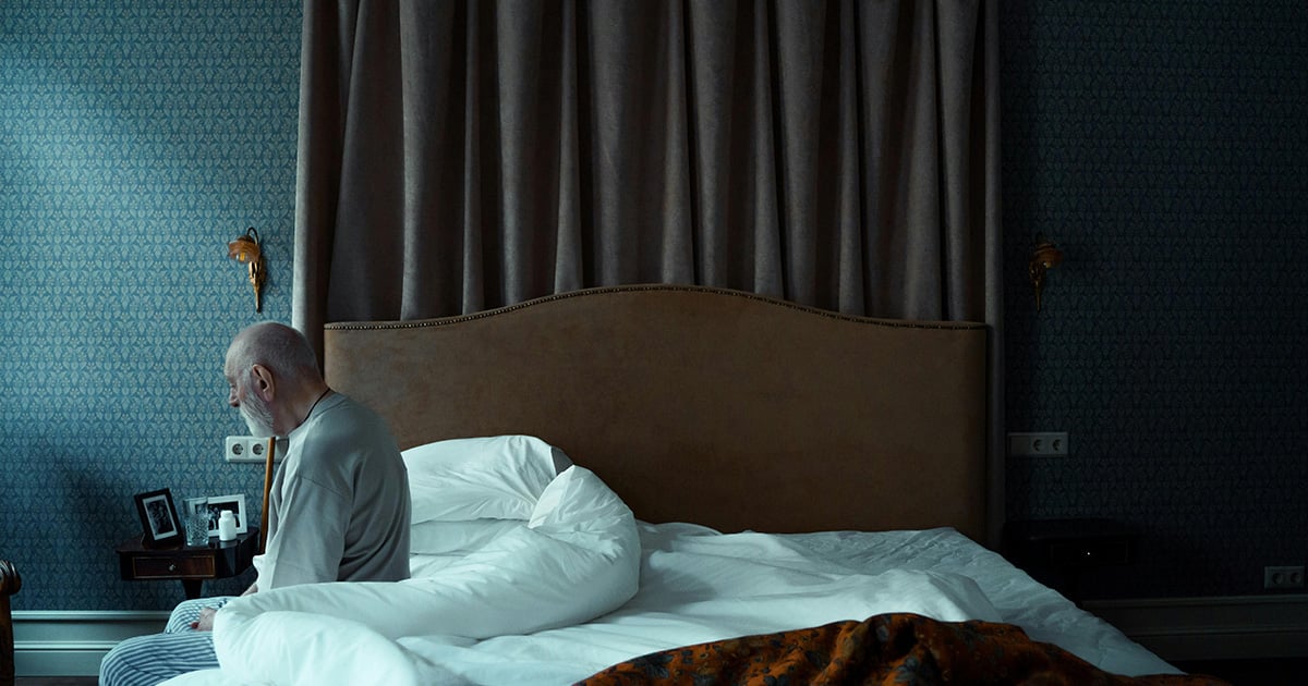 Woman sits on a couch and supports her head