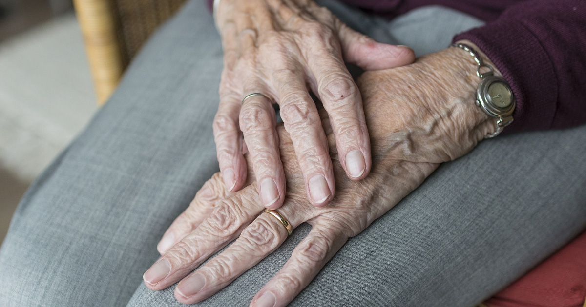 Hands of an old person placed on her lap