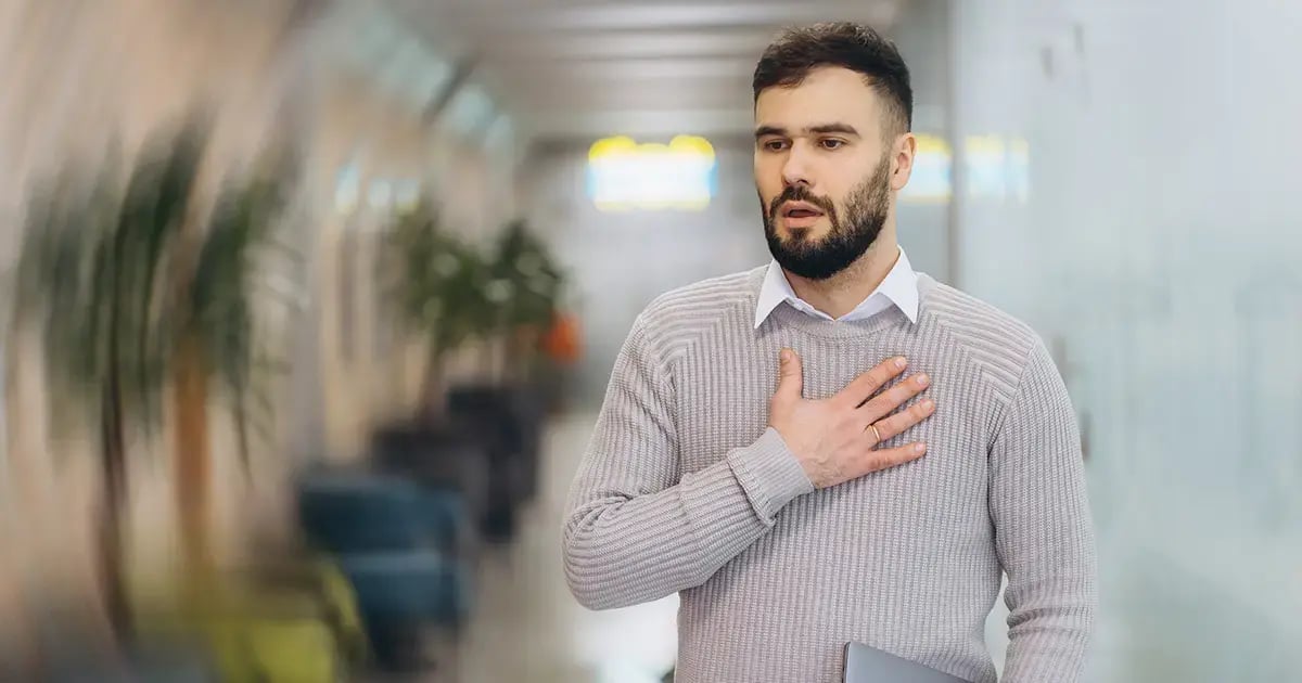 Mann hat Panikattacke, hält sich die Brust