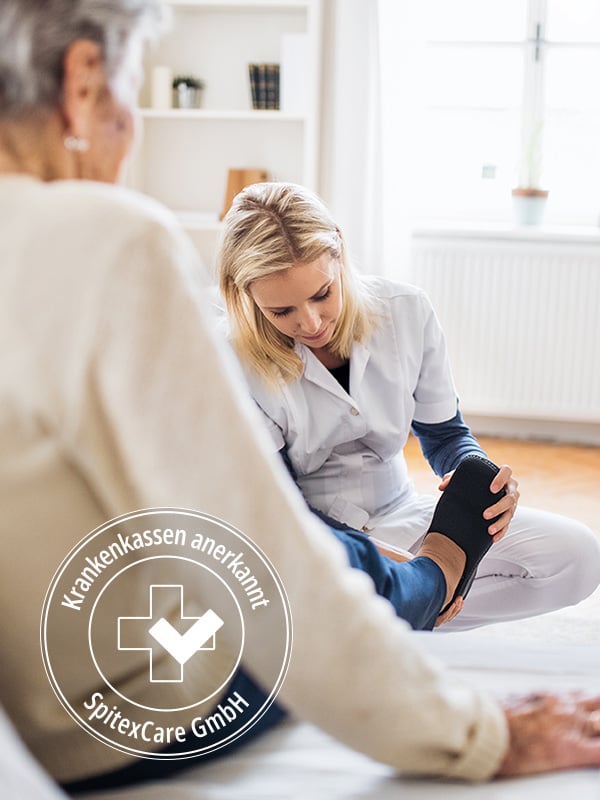 Spitex-Mitarbeiterin zieht Patienten zu Hause Schuhe an. Siegel 