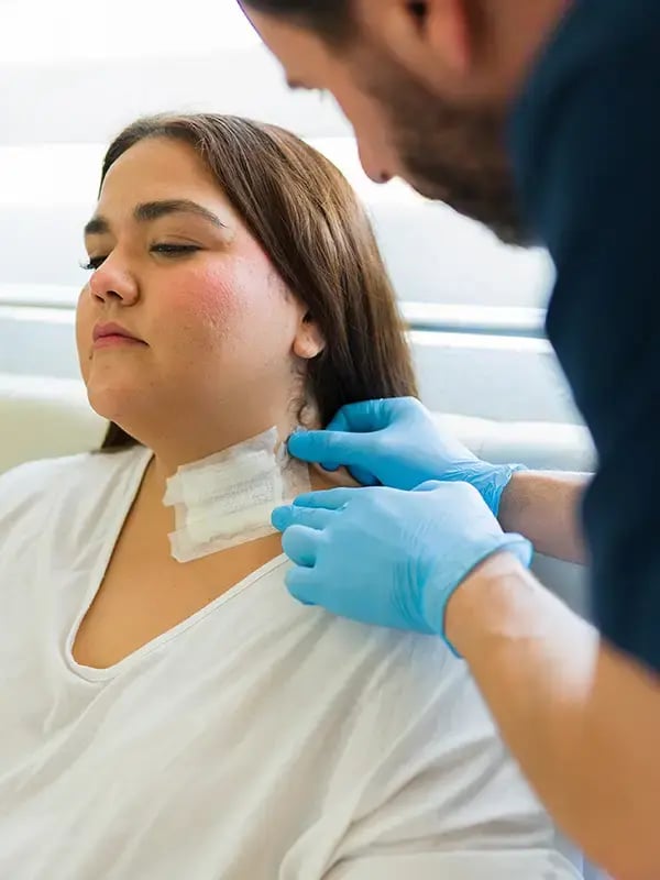 Wundversorgung am Hals einer Patientin durch Spitex