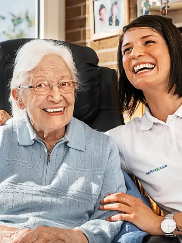 Pflegerin und Patientin lachen zusammen